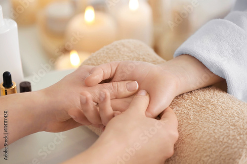 Young woman receiving hand massage in spa salon photo