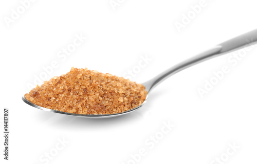 Heap of brown sugar in spoon, isolated on white
