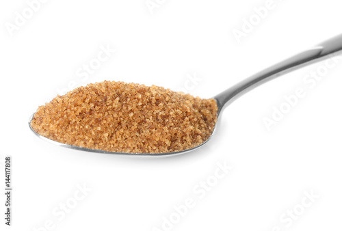 Heap of brown sugar in spoon, isolated on white