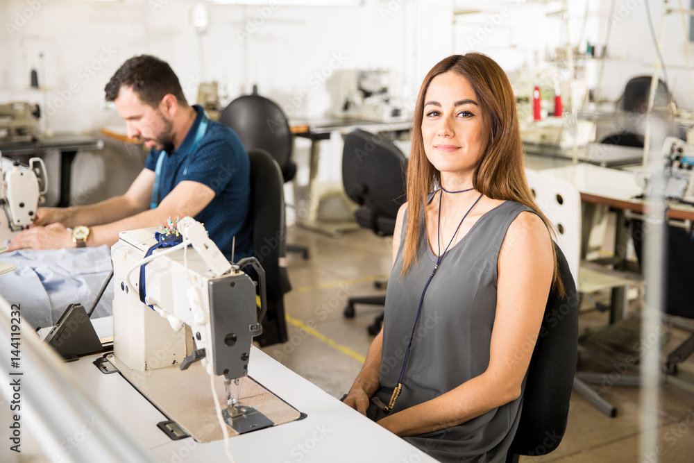 Cute seamstress working in a factory Cute seamstress working in a factory
