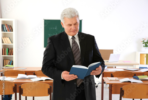 Senior teacher with book st...