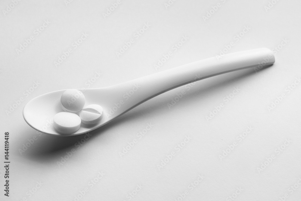 spoon with pills isolated on white background spoon with pills isolated on white background