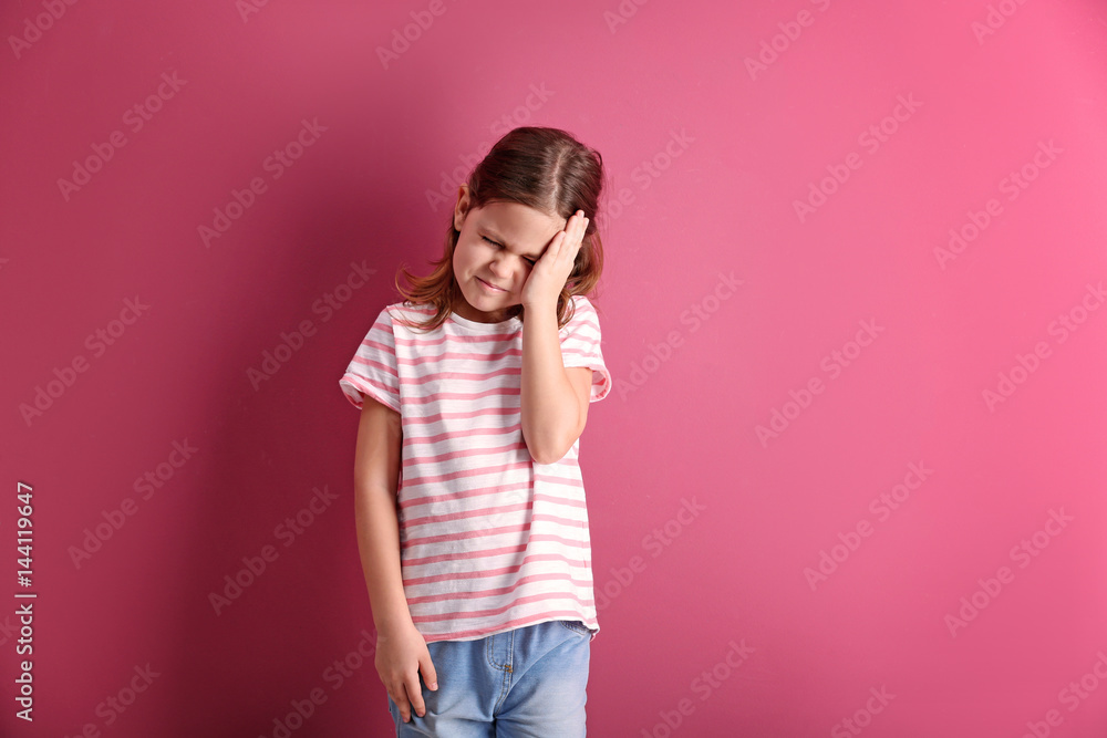 Little girl suffering from headache on color background Little girl suffering from headache on color background