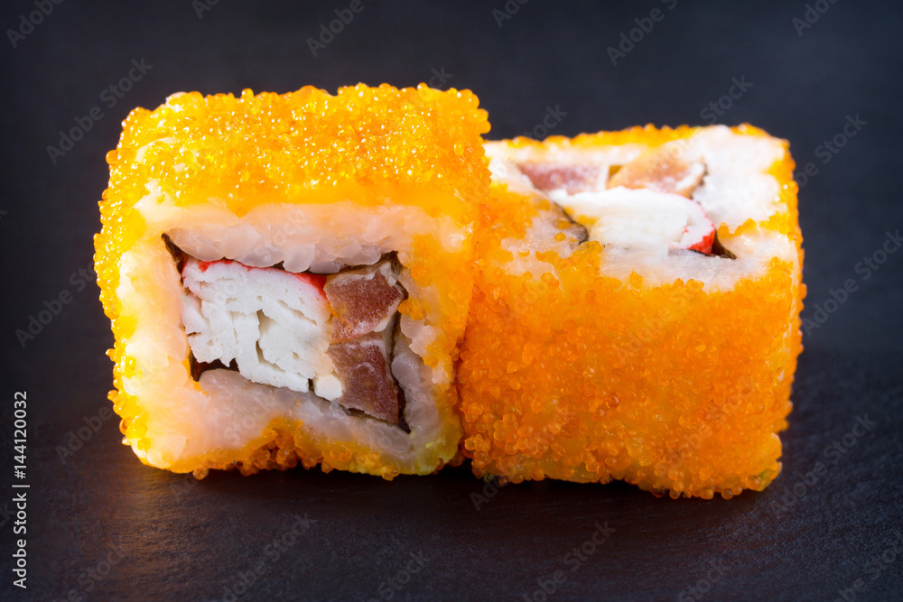 Roll Mr.Krabs isolate on a black slate board - red tobiko caviar, mayonnaise, crab meat (imitation), tomato, nori, rice. Roll Mr.Krabs isolate on a black slate board - red tobiko caviar, mayonnaise, crab meat (imitation), tomato, nori, rice.