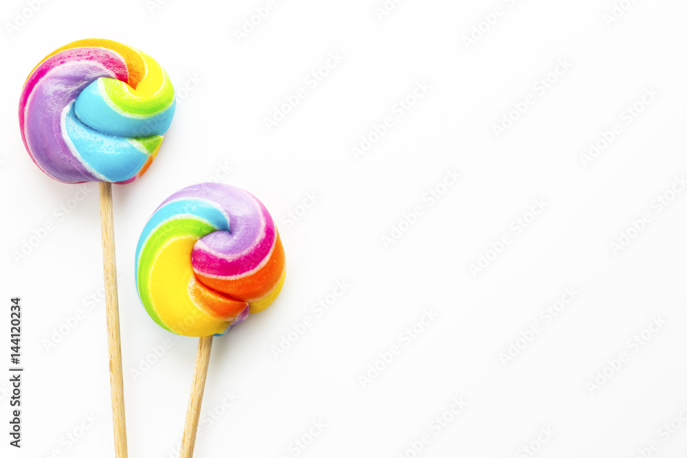 two rainbow color lollipops on white background two rainbow color lollipops on white background