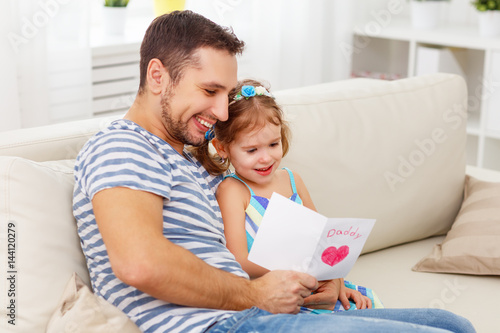 Father's day. Happy family daughter giving dad greeting card
