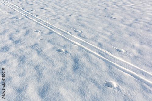 Ski track crossing white snowdrift