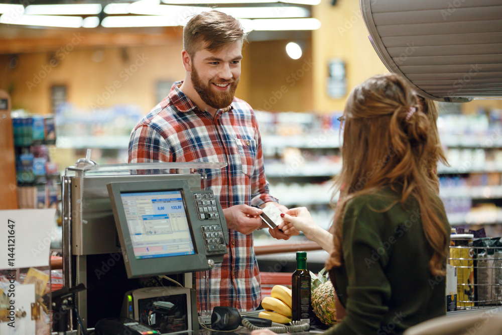 © Drobot Dean - Happy young man standing in supermarket shop