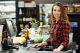 Cashier lady on workspace in supermarket shop