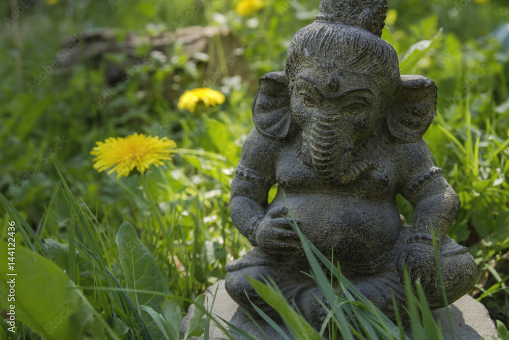 ganesh stone statue decoration on the green grass