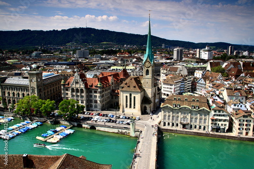 Cityscape of Zurich old town: the reformed Fraumunster Church, Munsterbrucke bridge on the river Limmat in the city center, Uetliberg in the background, seen from Grossmunster cathedral, Switzerland. photo