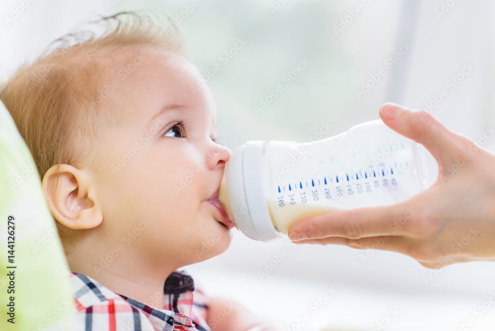 Mother feeds baby from a bottle of milk Mother feeds baby from a bottle of milk