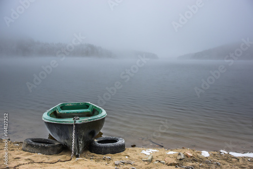 wooden rowing boat on foggy lake, wallpaper