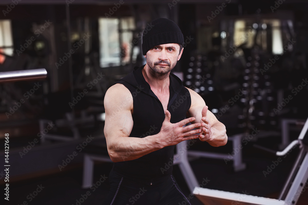 Strong ripped adult man with perfect abs, shoulders, biceps, triceps and chest posing in gym Strong ripped adult man with perfect abs, shoulders, biceps, triceps and chest posing in gym