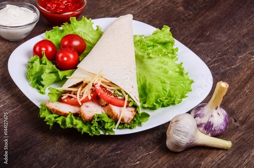 Burito with fried meat and tomatoes