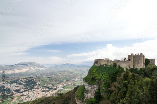 A middle age castle located on Erice (Italy, Sicily, province of Trapani) with hills and a little plain town in the background