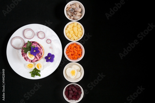 Dressed herring. Layered salad with herring. On a black background.