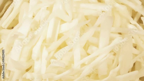 Chopped cabbage in white cup on wooden background close up. Ingredient for vegetable salad
