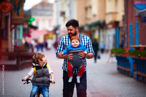 Canvas Print happy father and two sons on the city walk