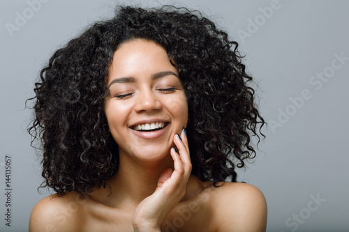 Smiling woman with bare shoulders and closed eyes