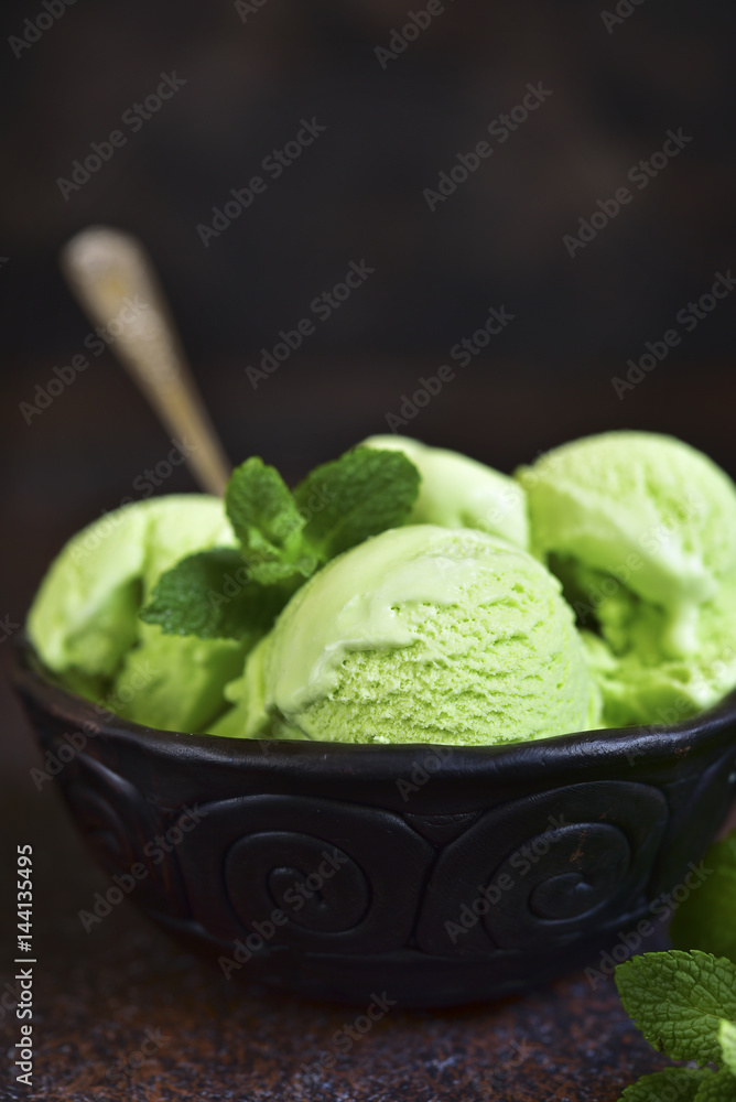 Pistachio ice cream in a clay bowl . Pistachio ice cream in a clay bowl .