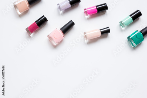 Bottles with nail polish over white background top view mockup