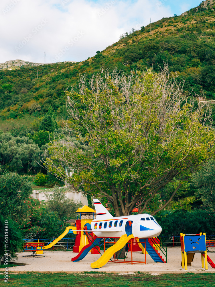 Children's playground with slides and swings. Children's slide in the form of an airplane. Park Sveti Stefan, Montenegro.