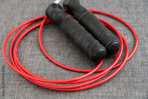 Red jump rope on a gray background 