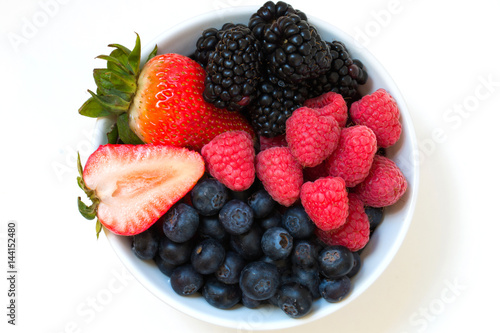 Organic fresh mixed berries fruit in a bowl on the table.