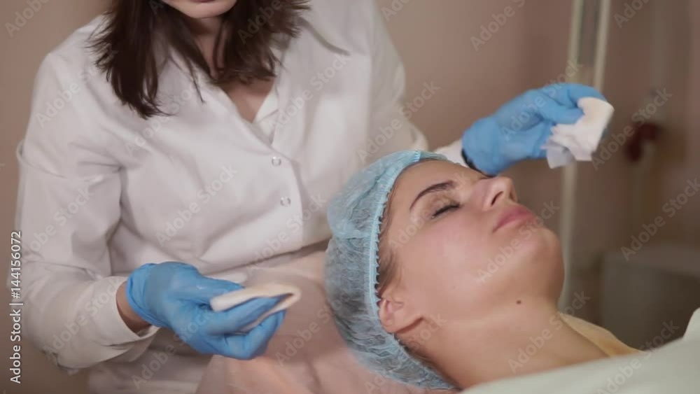 Close up of female patient receiving facial mask in spa beauty salon. Cosmetologist performing beauty treatment. Revitalization cosmetology. Close up of female patient receiving facial mask in spa beauty salon. Cosmetologist performing beauty treatment. Revitalization cosmetology.