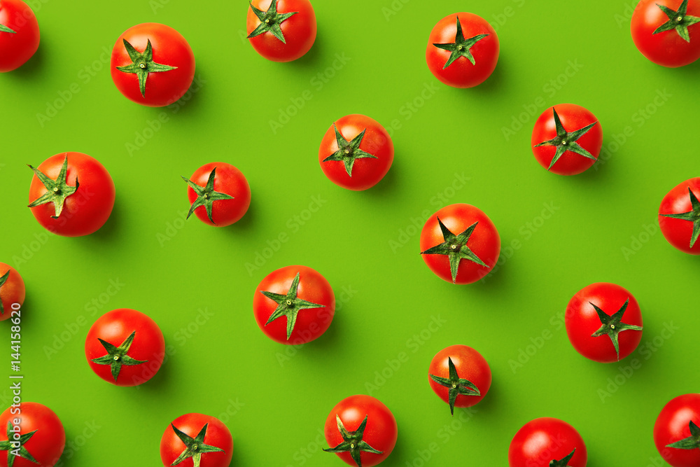 Cherry tomato pattern on a green background. Flat lay, top view Cherry tomato pattern on a green background. Flat lay, top view