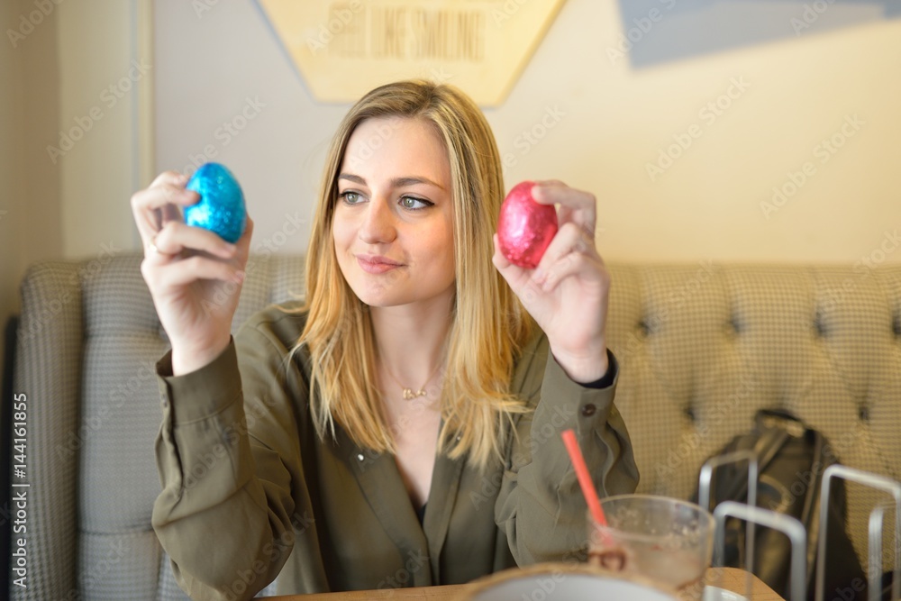 Beautiful blonde woman choosing her easter egg