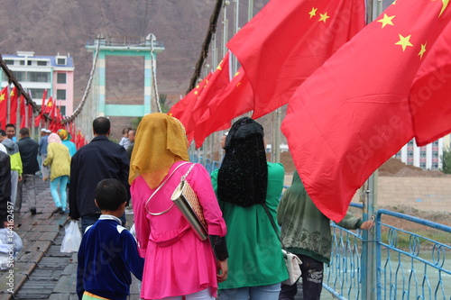 China Qinghai Xunhua Salar Muslim Islam Islamic Woman Women Muslims Bridge Flag Flags National Nationality Red Headscarf Headscarves Asia Asian Itentity  photo
