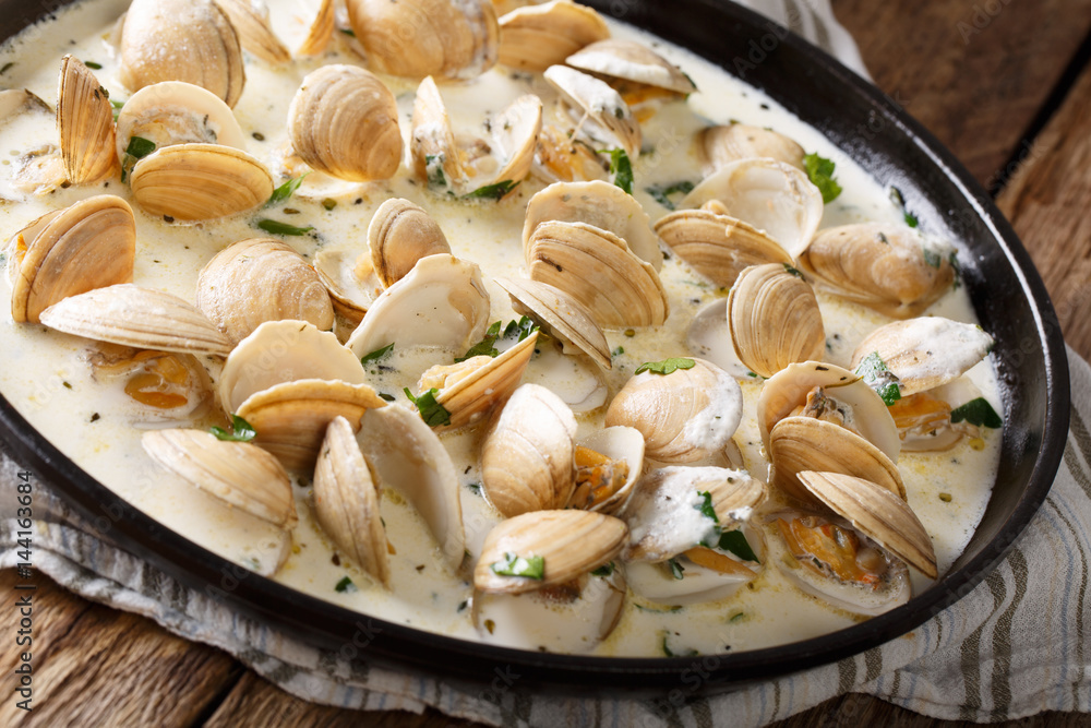Stewed clam in a creamy sauce with herbs and garlic close-up. horizontal Stewed clam in a creamy sauce with herbs and garlic close-up. horizontal