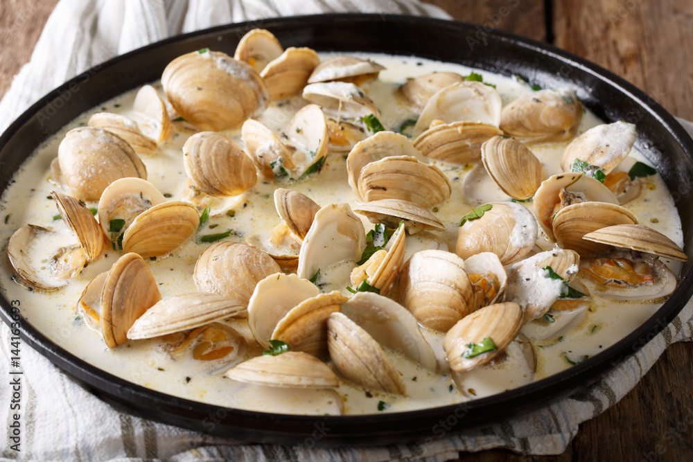 Stewed clam in creamy sauce with herbs close-up. horizontal Stewed clam in creamy sauce with herbs close-up. horizontal