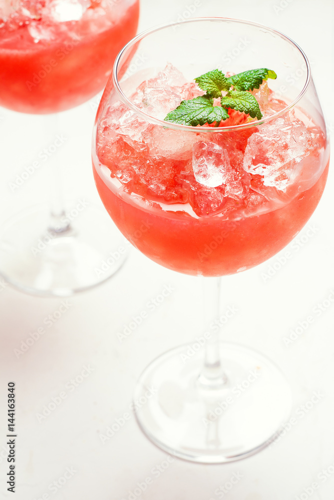 Strawberry cocktail with mint and ice in wine glasses. Strawberry cocktail with mint and ice in wine glasses.