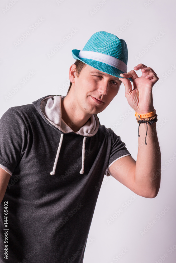 Charming handsome young man in formalwear Holds a blue hat white background