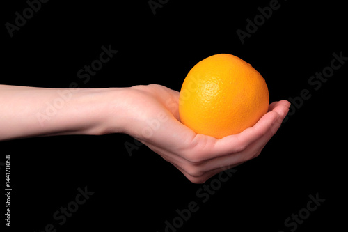 orange in hand black background