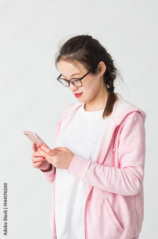 Portrait of beautiful young woman playing her mobile phone.