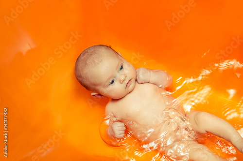 Valokuva bathing baby in water in the mother's arms the joy of laughter