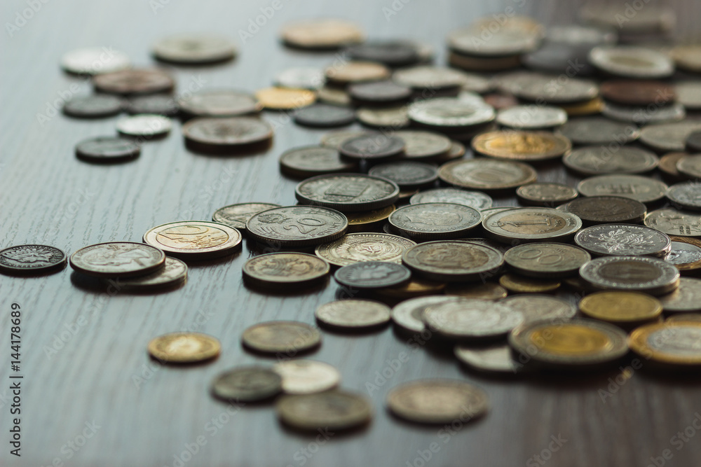 Different gold and silver collector's coins on the wooden table Different gold and silver collector's coins on the wooden table