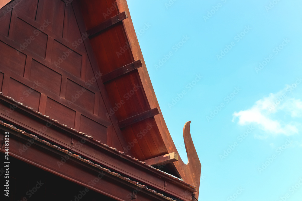 Wooden roof of Thai style house with blue sky