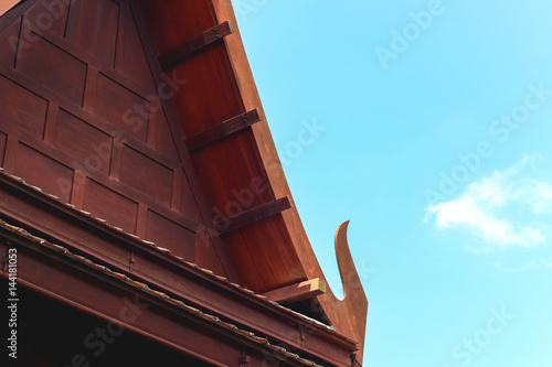 Wooden roof of Thai style house with blue sky © bookybuggy