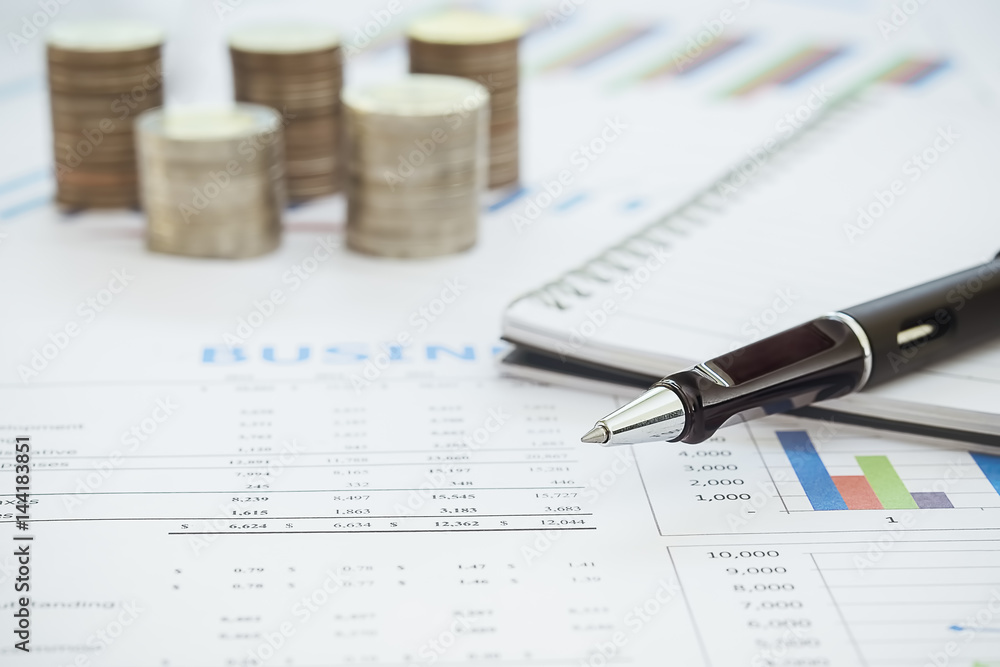 Business diagram on financial report with coins and calculator Business diagram on financial report with coins and calculator