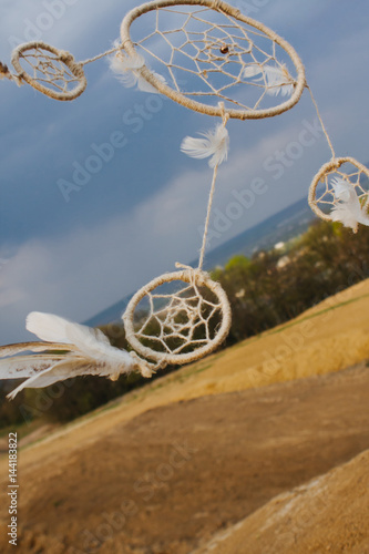 dream catcher hanging  in a dry field at sunset.