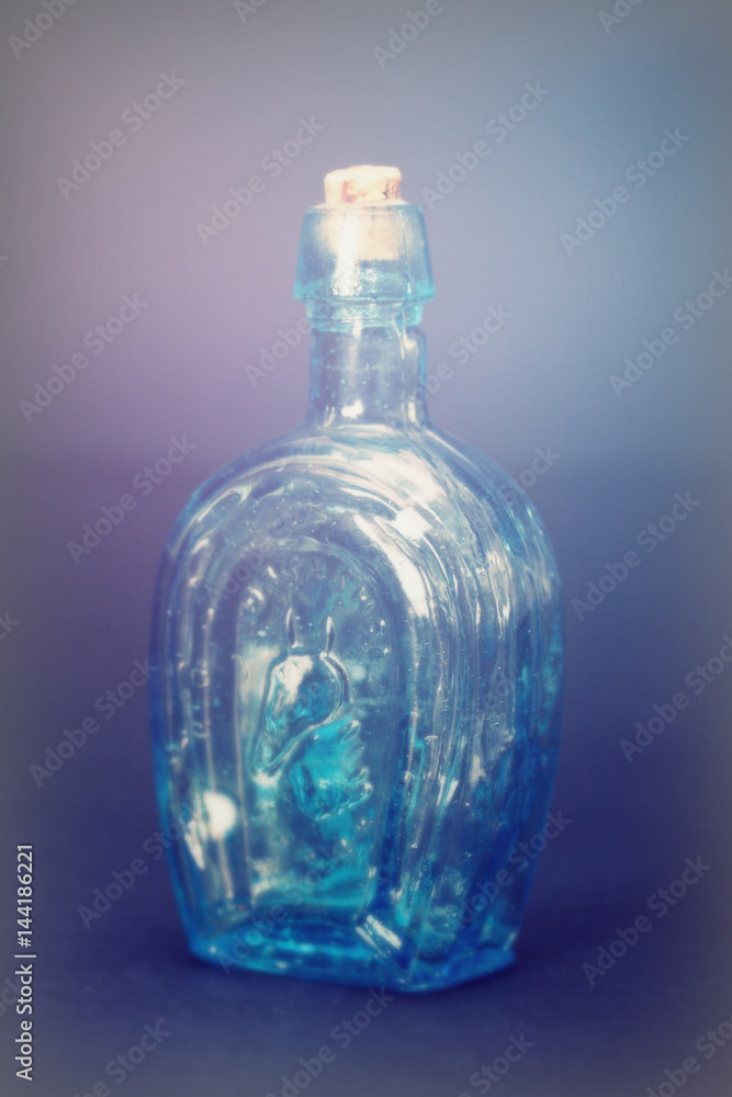 Old colourful bottles against a dark background Old colourful bottles against a dark background