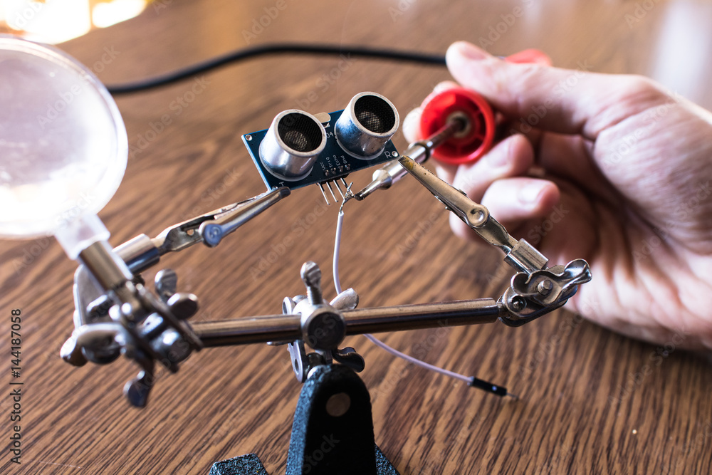 Soldering an ultrasonic sensor. Robotics for kids lesson Stock Photo ...