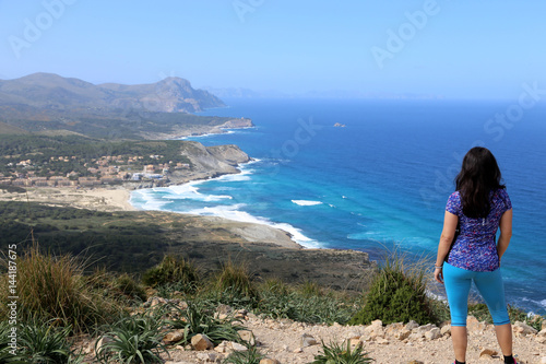 Blick über die Schulter einer Frau, die auf die Küste von Mallorca schaut