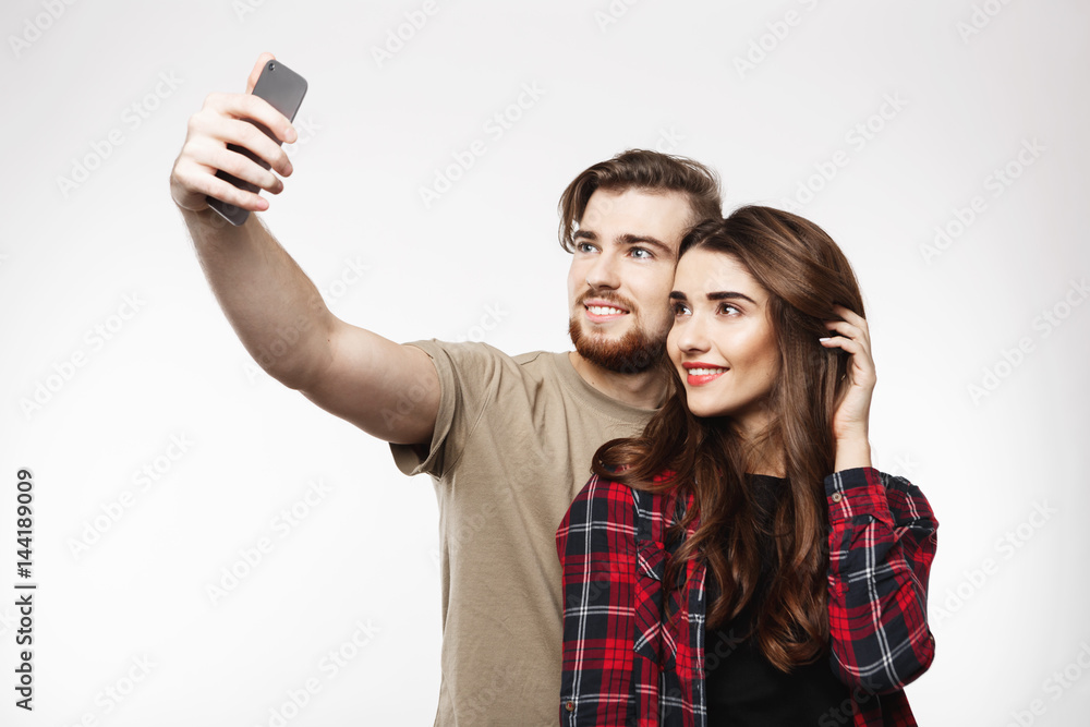 Nice cheerful couple taking selfie on phone, looking happy. Nice cheerful couple taking selfie on phone, looking happy.