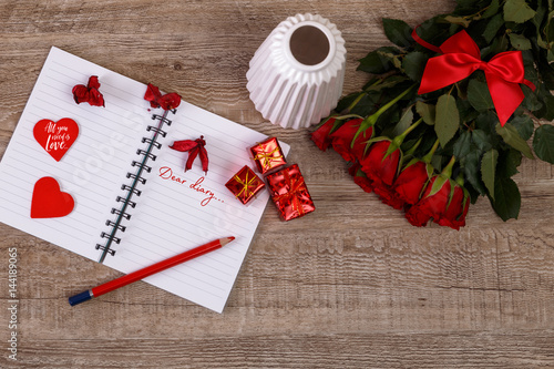 Red roses with hearts, gift boxes and vase. Valentines day concept. Red pencil with notebook. All you need is love.